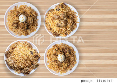 Set of popular biryani dishes on white plate on wooden table background. Set of popular biryani dishes on white plate on wooden table background. 115401411