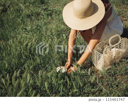 Woman Foraging Wild Mushroom in Sunny Grassland Wearing Summer Dress Woman Foraging Wild Mushroom in Sunny Grassland Wearing Summer Dress 115401747