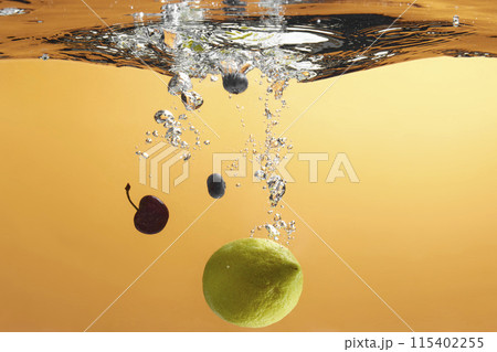Fresh fruit falling into the water. Organic fruits for making effective juices for dieting. 115402255
