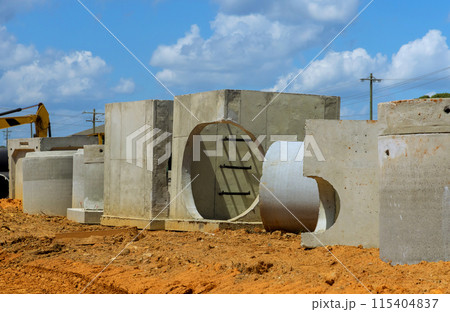 Stack of concrete drainage wells for water discharge in aconstruction site prior to their installation 115404837