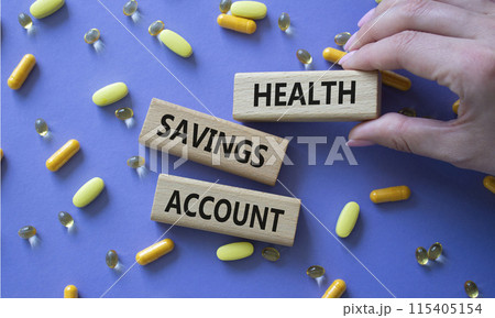 Health Saving Account symbol. Concept word Health Saving Account on wooden blocks. Doctor hand. Beautiful purple background with pills. Medicine and Health Saving Account concept. Copy space 115405154