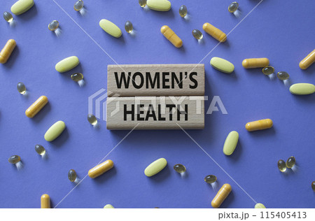 Womens health symbol. Concept word Womens health on wooden blocks. Beautiful purple background with pills. Medicine and Womens health concept. Copy space Womens health symbol. Concept word Womens health on wooden blocks. Beautiful purple background with pills. Medicine and Womens health concept. Copy space 115405413