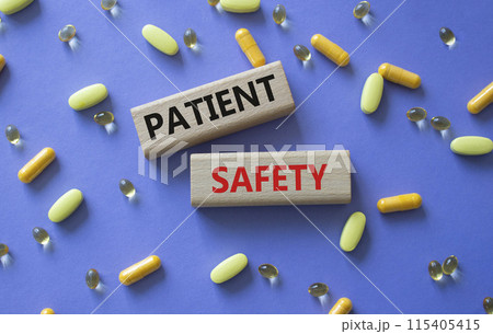 Patient Safety symbol. Concept word Patient Safety on wooden blocks. Beautiful purple background with pills. Medicine and Patient Safety concept. Copy space Patient Safety symbol. Concept word Patient Safety on wooden blocks. Beautiful purple background with pills. Medicine and Patient Safety concept. Copy space 115405415