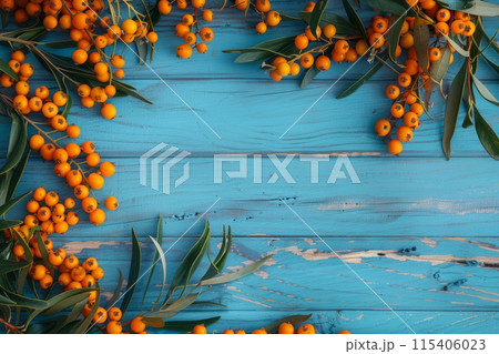 Buckthorn berries on a blue rustic wooden background 115406023