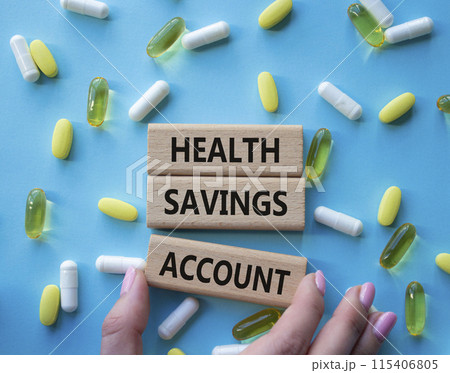Health Saving Account symbol. Concept word Health Saving Account on wooden blocks. Doctor hand. Beautiful blue background with pills. Medicine and Health Saving Account concept. Copy space Health Saving Account symbol. Concept word Health Saving Account on wooden blocks. Doctor hand. Beautiful blue background with pills. Medicine and Health Saving Account concept. Copy space 115406805