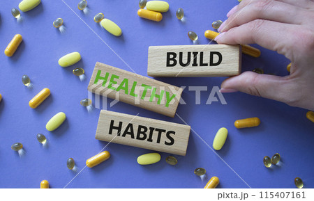 Healthy habits symbol. Concept word Build Healthy habits on wooden blocks. Doctor health. Beautiful purple background with pills. Healthy lifestyle and Healthy habits concept. Copy space Healthy habits symbol. Concept word Build Healthy habits on wooden blocks. Doctor health. Beautiful purple background with pills. Healthy lifestyle and Healthy habits concept. Copy space 115407161