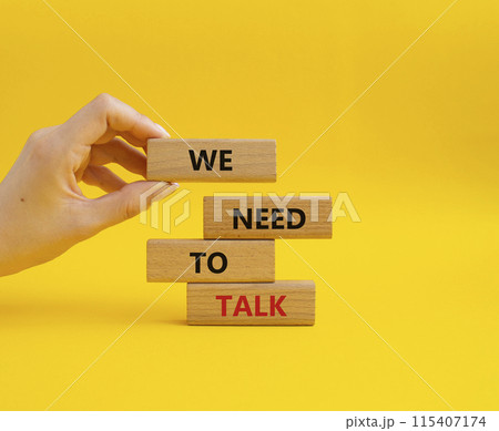 We need to talk symbol. Concept words We need to talk on wooden blocks. Beautiful yellow background. Businessman hand. Business and We need to talk concept. Copy space. 115407174
