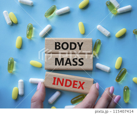 Body Mass Index symbol. Concept word Body Mass Index on wooden blocks. Doctor health. Beautiful blue background with pills. Medicine and Body Mass Index concept. Copy space Body Mass Index symbol. Concept word Body Mass Index on wooden blocks. Doctor health. Beautiful blue background with pills. Medicine and Body Mass Index concept. Copy space 115407414