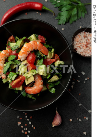 Salad of king prawns, avocado, cucumber, tomato and herbs. Black background Salad of king prawns, avocado, cucumber, tomato and herbs. Black background 115407542