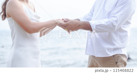 Happy young, Portrait of a young couple holding hands, the groom holds the bride's hand on the background of a natural country, the bride and groom Happy young, Portrait of a young couple holding hands, the groom holds the bride's hand on the background of a natural country, the bride and groom 115408822