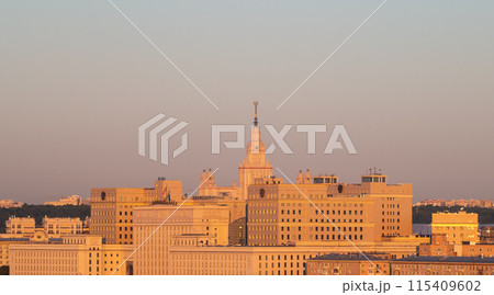 View of the building of Moscow State University (MSU) and the situation center of the Ministry of Defense in the rays of the dawn sun on a summer morning 115409602