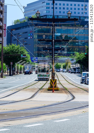 うららかな青空日和に映える熊本駅周辺風景(東口駅前・交通機関)【東口　路面電車　祇園橋方面から撮影】 115411620
