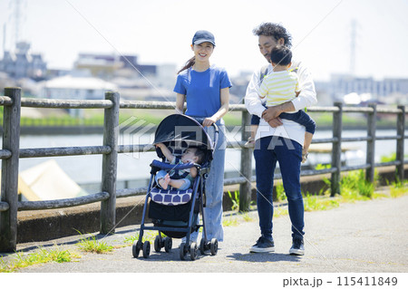 川の土手をベビーカーを押しながら歩く親子 川の土手をベビーカーを押しながら歩く親子 115411849