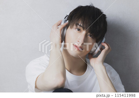 ヘッドフォンで音楽を聴く若い男性　 115411998