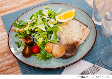 Fried porbeagle steak with vegetable salad and lemon wedge Fried porbeagle steak with vegetable salad and lemon wedge 115413229