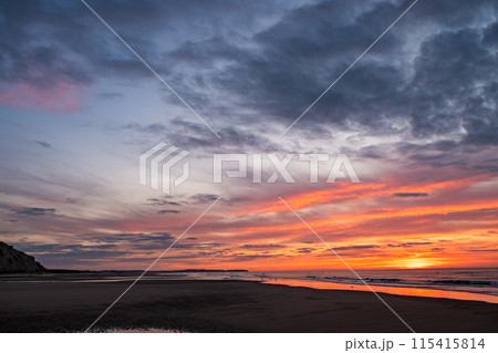 Experience a breathtaking coastal sunset with vibrant skies and the soothing sound of ocean waves 115415814