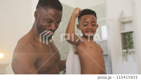 Image of lights over happy african american father and son taking selfie in bathroom 115415933