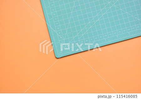 green cutting mat on orange background, object tool for design green cutting mat on orange background, object tool for design 115416085