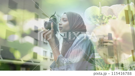 Image of asian woman in hijab with camera over cityscape 115416788