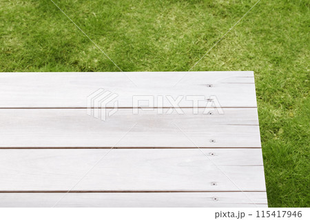 芝生背景にヴィンテージな木目のテーブル。キャンプやアウトドアイメージのディスプレイ 芝生背景にヴィンテージな木目のテーブル。キャンプやアウトドアイメージのディスプレイ 115417946