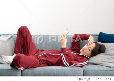 ソファーでスマホを見る女性　ストレス 115420573