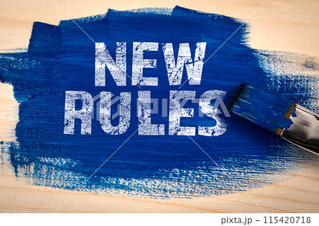 NEW RULES. Blue paint and paint brush on wooden texture background NEW RULES. Blue paint and paint brush on wooden texture background 115420718