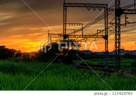 奈良平城京跡朱雀門ひろばの夕景 空とレールを黄金色に染めながら西大寺駅方向へ沈んで行く夕日③ 奈良平城京跡朱雀門ひろばの夕景 空とレールを黄金色に染めながら西大寺駅方向へ沈んで行く夕日③ 115420765