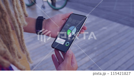 A person checks financial charts on a smartphone outdoors 115421827