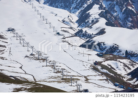 End of season, empty ski resort slope with four chairlifts, view above. Winter sports activities. Recreation place 115423195