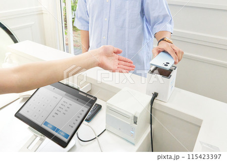 キャッシュレス決済を行うお客と店員の手元 キャッシュレス決済を行うお客と店員の手元 115423397