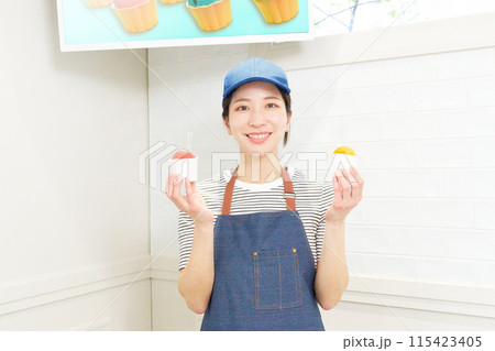 笑顔でジェラートを手に持つ女性販売スタッフ 115423405