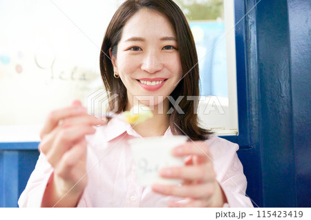 笑顔でジェラートを勧める若い女性 笑顔でジェラートを勧める若い女性 115423419