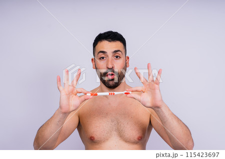 Portrait, man or wellness with toothbrush, oral hygiene or body care on grey studio background. Portrait, man or wellness with toothbrush, oral hygiene or body care on grey studio background. 115423697