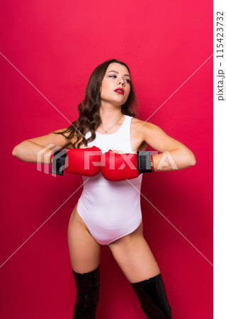 Attractive young brunette woman in boxers gloves, studio shot Attractive young brunette woman in boxers gloves, studio shot 115423732