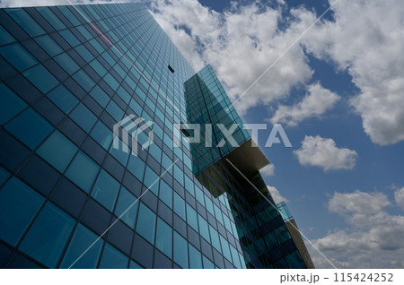 Vienna, Austria, August 17, 2022. Donau City is the city district characterized by modern skyscrapers, in the photo the detail of a glass facade. Play of reflections between the surfaces. 115424252
