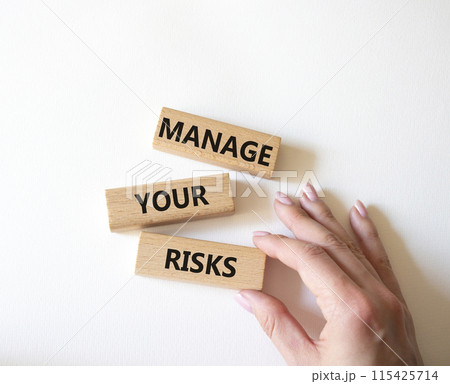 Manage your Risks symbol. Concept words Manage your Risks on wooden blocks. Businessman hand. Beautiful white background. Business and Manage your Risks concept. Copy space. 115425714