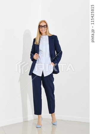 Fashion model demonstrates a classic fitted suit for everyday work in the office Fashion model demonstrates a classic fitted suit for everyday work in the office 115425815