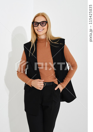 Three quarter length portrait of happy blonde woman looking to the side with cute attractive smile 115425835