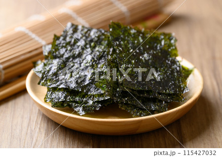 Dried seaweed sheet on wooden plate, Asian food ingredient 115427032