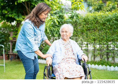 Caregiver help and care Asian senior woman patient sitting on wheelchair at nursing hospital ward, healthy strong medical. Caregiver help and care Asian senior woman patient sitting on wheelchair at nursing hospital ward, healthy strong medical. 115428635
