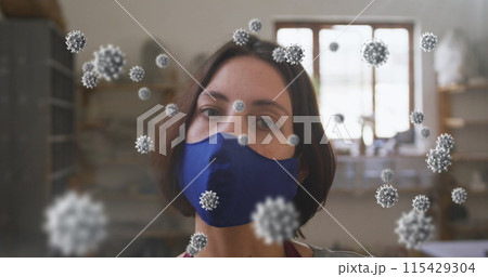 Image of covid 19 cells over woman in pottery studio wearing face mask Image of covid 19 cells over woman in pottery studio wearing face mask 115429304