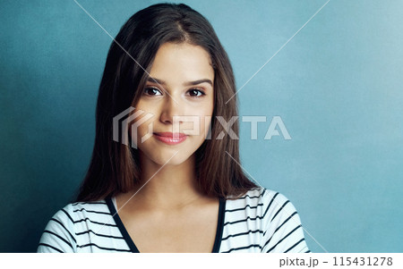 Girl, smile and portrait or beauty in studio with skincare, cosmetics or glowing skin with mockup space. Woman, model or person with facial treatment on blue background with wellness, makeup or happy 115431278