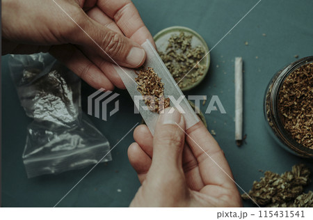 man at a table about to make a joint 115431541