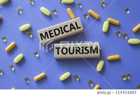 Medical Tourism symbol. Concept word Medical Tourism on wooden blocks. Beautiful purple background with pills. Medicine and Medical Tourism concept. Copy space 115431665
