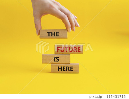 The future is here symbol. Concept words The future is here on wooden blocks. Beautiful yellow background. Businessman hand. Business and The future is here concept. Copy space. 115431713