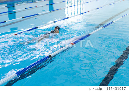 A swimmer practices in a pool, with copy space 115431917
