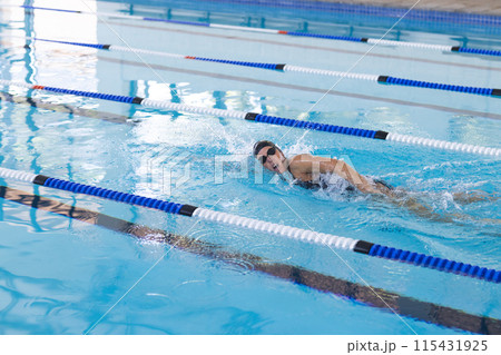 Caucasian female athlete swimmer swimming laps in a pool Caucasian female athlete swimmer swimming laps in a pool 115431925