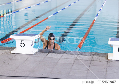 Caucasian female athlete swimmer celebrates victory in a swimming competition 115431967