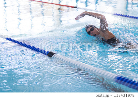 Caucasian female athlete swimmer swims in an indoor pool 115431979