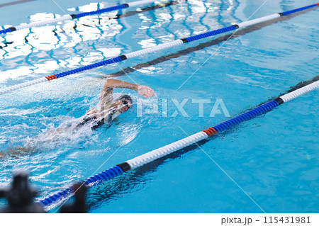 Swimmer in action at an indoor pool, with copy space Swimmer in action at an indoor pool, with copy space 115431981
